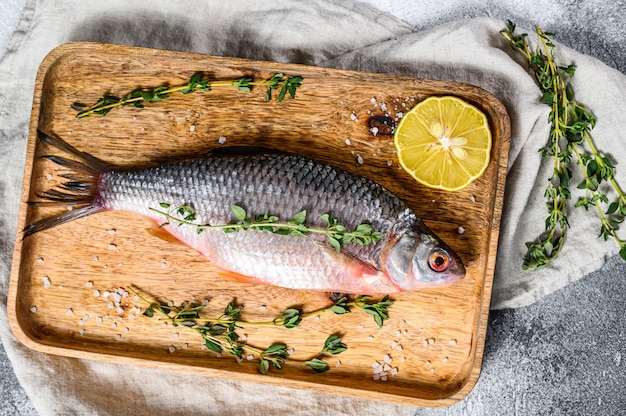 Carpa crucian su un vassoio di legno. Pesce biologico di fiume. Vista dall'alto