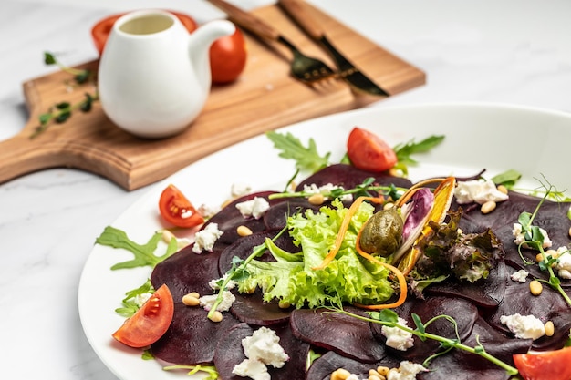 Carpaccio di barbabietola con feta, rucola e olio d'oliva. cucina italiana. Deliziosa colazione o spuntino, cibo pulito, dieta, concetto di cibo vegano. vista dall'alto