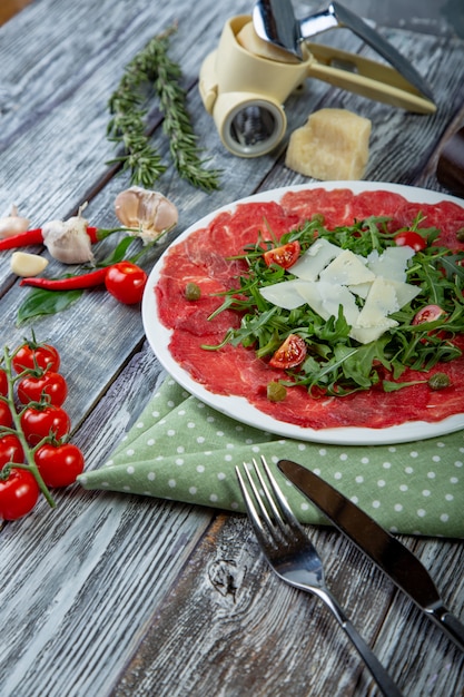 carpaccio di carne con rucola e fette di parmigiano