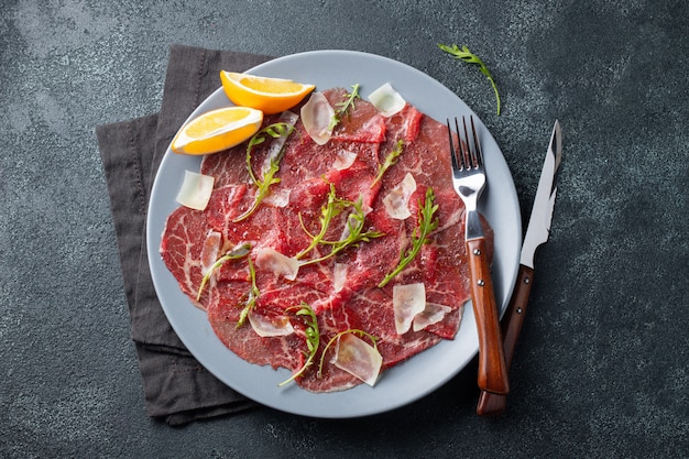 Carpaccio di manzo marmorizzato con rucola e parmigiano.