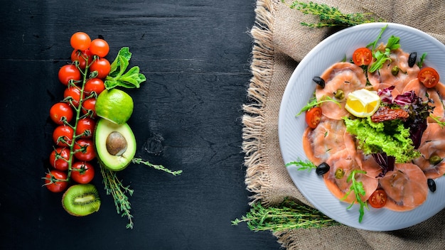 Carpaccio di pesce verdure formaggio spezie a Fondo in legno Vista dall'alto Spazio libero