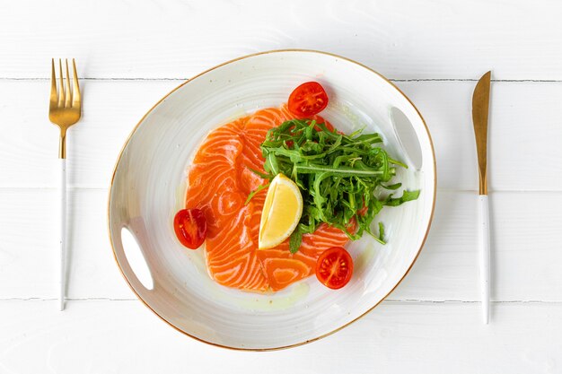 Carpaccio di salmone servito con limone e rucola