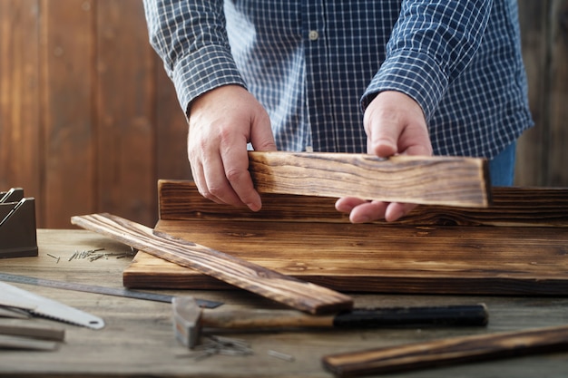 Carpentiere che lavora con gli strumenti sulla parete di legno