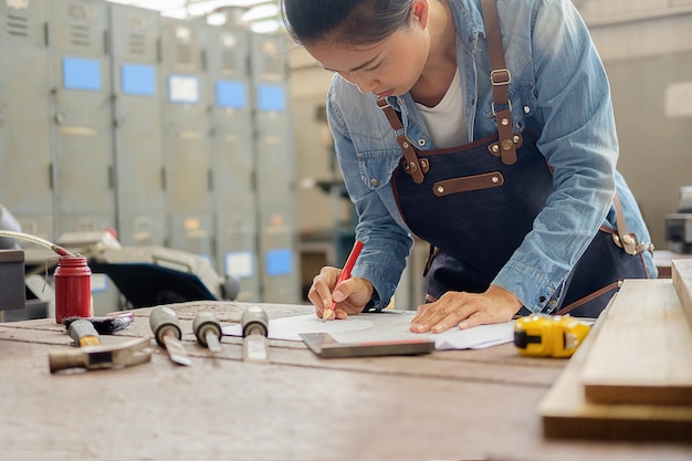 Carpentiere che lavora su macchine per la lavorazione del legno nel negozio di falegnameria