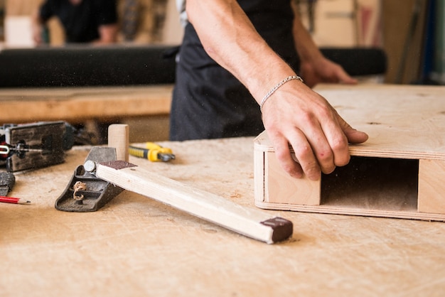 Carpentiere che produce mobili in legno in officina