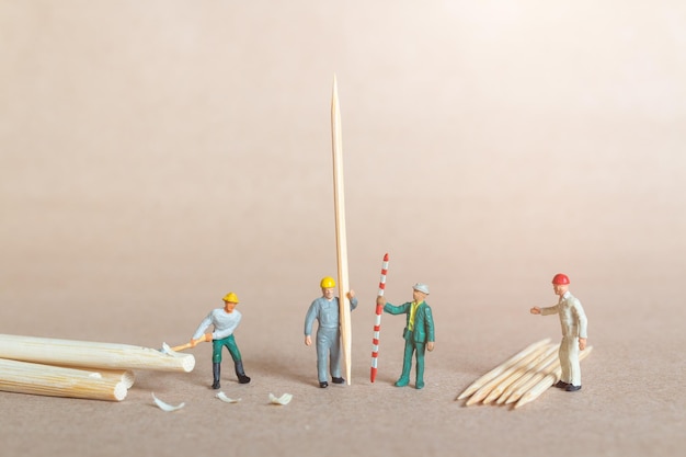 Carpentiere di persone in miniatura che fa stuzzicadenti di bambù da bambù, concetto di riciclaggio