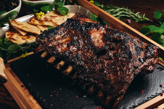 Carrè di agnello arrosto alla griglia su tavola di legno