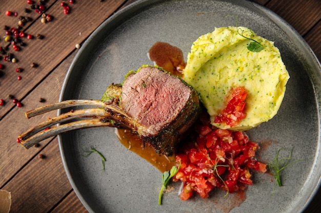 Carrè di agnello con purè di patate su fondo di legno