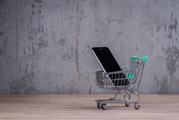 Carrello con smart phone all'interno sul tavolo di legno