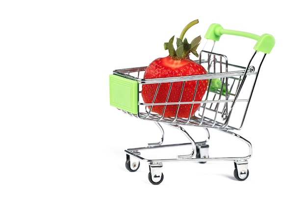 Carrello del supermercato con fragole su sfondo bianco Vendita di frutti di bosco