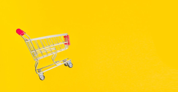 Carrello della spesa del supermercato su sfondo giallo