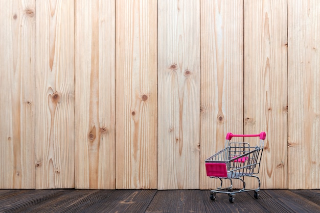 Carrello della spesa o carrello del supermercato su legno