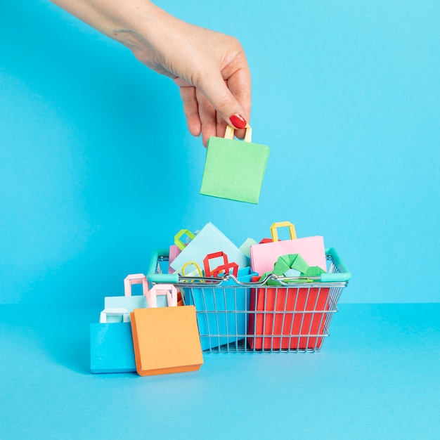 Carrello della spesa pieno di sacchetti di carta shopping concetto di dipendenza