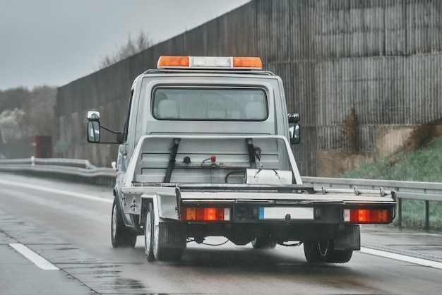 Carrello di traino a pianale vuoto trasportatore di auto vuoto e veicolo di rimorchio a pianale piatto che viaggia su una strada nazionale