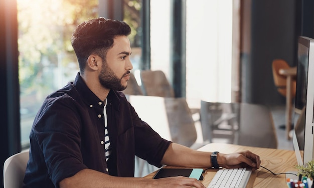 Carriera lavorativa uomo e computer in ufficio come dipendente designer creativo e grafico Persona maschile seria e tecnologica in agenzia digitale per progetti aziendali o scadenza con ambizione in azienda