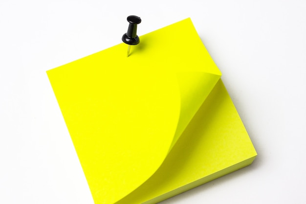 Carta adesiva gialla con pulsante, arricciata su uno sfondo bianco.