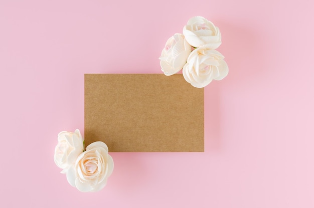 Carta beige e rose su sfondo rosa