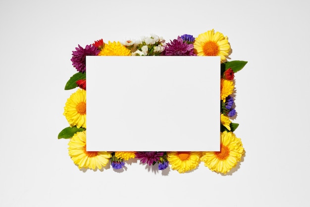 Carta bianca con copia spazio e boccioli di fiori vista dall'alto