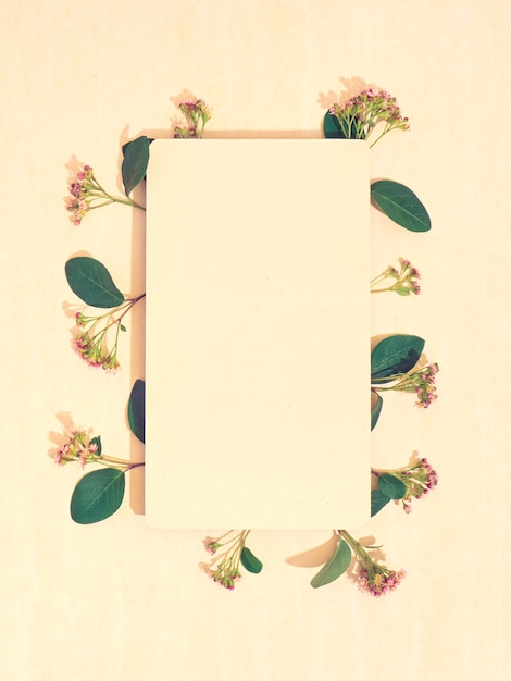 Carta bianca con cornice di fiori. Disposizione piatta, copia spazio, vista dall'alto.