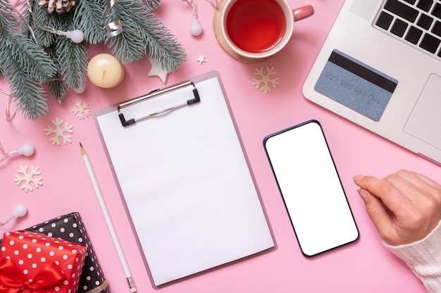 Carta bianca su tablet e telefono mock up carta di credito con Cristmas Capodanno decorazione tavolo da lavoro vista dall'alto piatto giaceva su sfondo rosa
