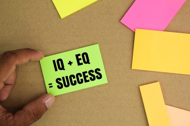 carta colorata con le lettere IQ EQ insieme alla formula del successo per il successo