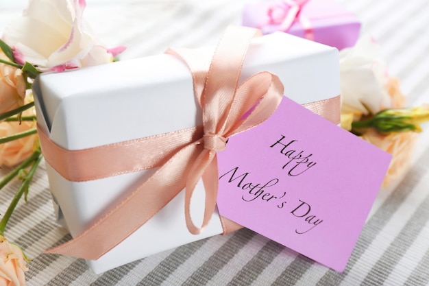 Carta con parole Happy Mother's day e confezione regalo sul tavolo