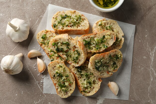 Carta da forno con pane all'aglio tostato sulla vista grigia e superiore