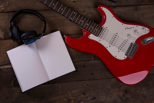 Carta da parati chitarra con microfono, cuffia, cavi e fondo in legno, con blocco di scrittura