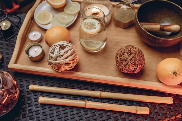 Carta da parati decorativa ad astrazione con vassoio in stile giapponese e candele profumate, bastoncini di bambù e limoni