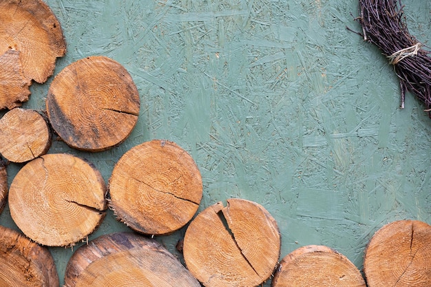 Carta da parati strutturata in legno con sfondo blu e fette marroni di legna da ardere e rami legati nell'angolo. Fondo naturale in legno massello.