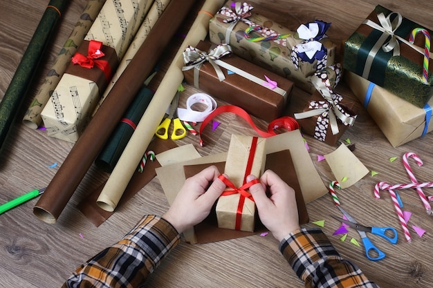 Carta da regalo a mano per il nastro natalizio natalizio e fiocchi