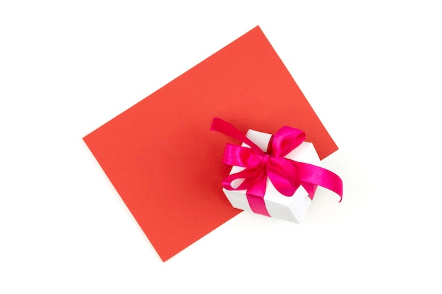 Carta di carta bianca con spazio per la copia Confezione regalo bianca con fiocco rosso Biglietto di auguri mock upIsolato su uno sfondo bianco