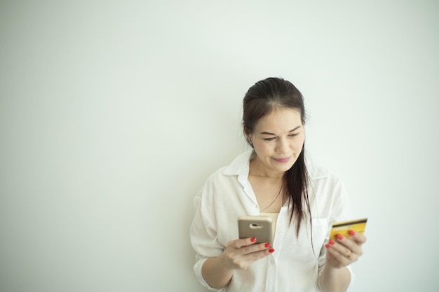 Carta di credito e telefono cellulare asiatici della tenuta della donna