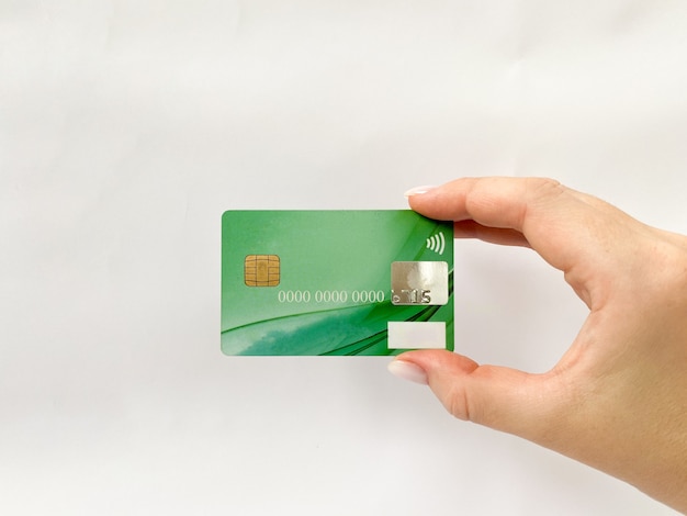Carta di credito in mano su uno sfondo bianco isolato