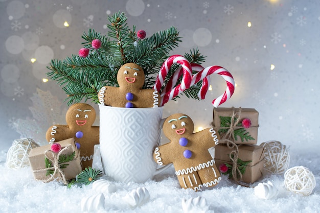 Carta di Natale o Capodanno. Coppa con abeti, bastoncini di zucchero e biscotti allo zenzero.