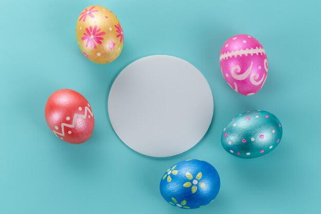 Carta di pasqua minima. Cinque uova di Pasqua decorate di colore alla moda su azzurro