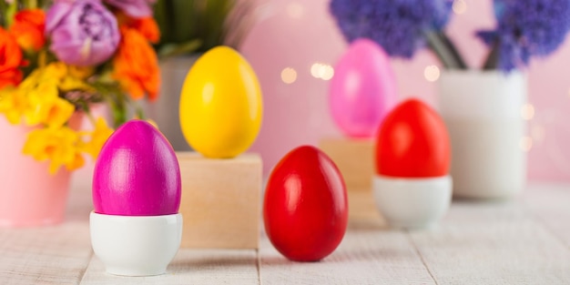 Carta di Pasqua Uova di Pasqua colorate sullo sfondo di un mazzo di fiori