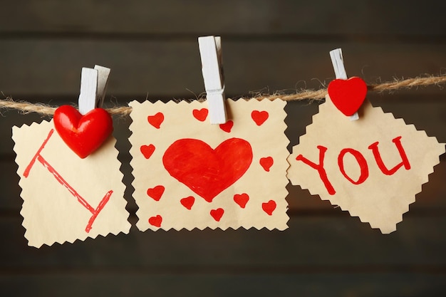 Carta di San Valentino con cuori e parole d'amore su fondo di legno