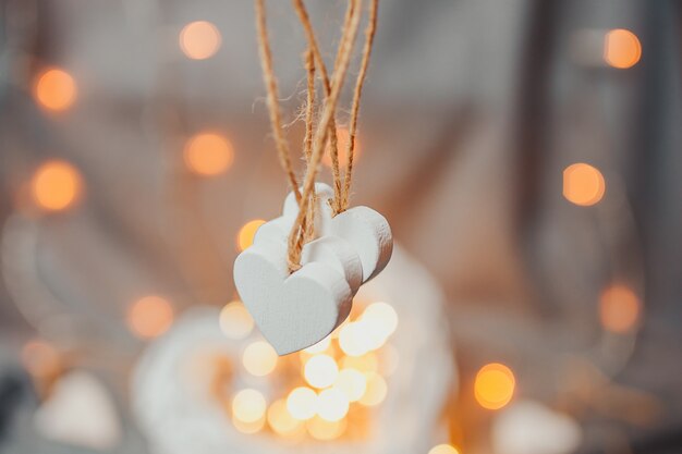 Carta di San Valentino. Cuore di legno bianco con bokeh luminoso. Cuori con luci ghirlanda.