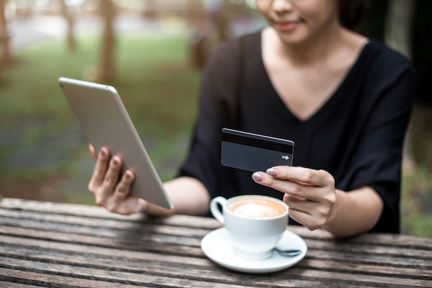 carta e compressa della tenuta della donna per lo shopping online.