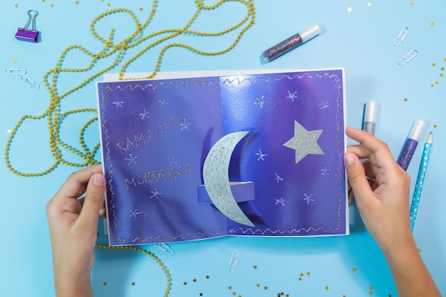 Carta fai da te Ramadan kareem con falce di luna d'argento e una stella. Idea regalo, arredamento Ramadan Kareem. Passo dopo passo. Vista dall'alto.