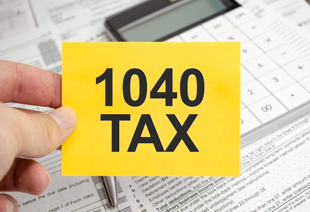 Carta gialla con le parole 1040 moduli fiscali e fiscali con calcolatrice