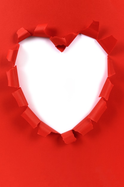 Carta lacerata di forma rossa del cuore del biglietto di S. Valentino, fondo bianco, spazio della copia