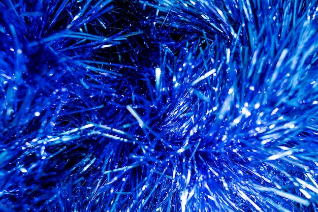 Carta metallica monocromatica brillante blu delle decorazioni di canutiglia di Buon Natale e del nuovo anno. Celebrazione del partito festivo e concetto del regalo struttura festiva del fondo del partito, stagnola metallica