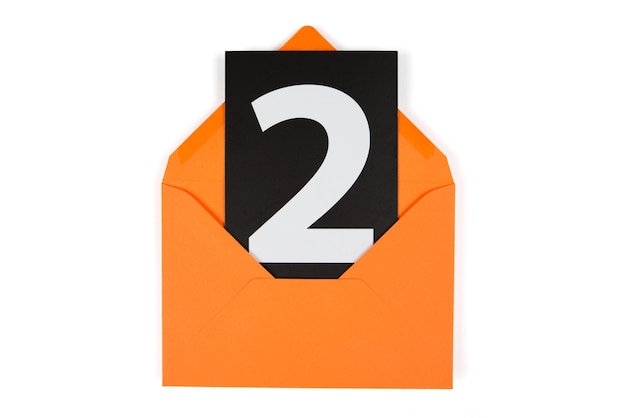 Carta nera con un numero bianco due in una busta di carta arancione