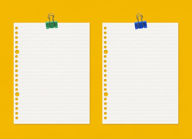 Carta per appunti vuota con clip su sfondo di carta patinata gialla e spazio per la copia per il tuo design