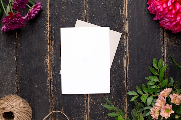 Carta regalo bianca con bellissimi fiori su un tavolo vintage scuro