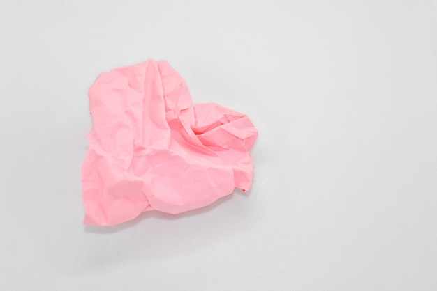 Carta rosa stropicciata a forma di cuore su sfondo bianco Spazio per il testo cartolina di dichiarazione d'amore di San Valentino