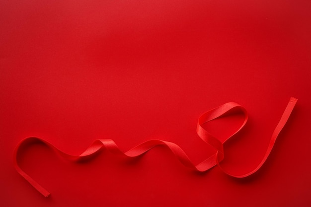 Carta rossa con cornice di nastro di raso rosso San Valentino o sfondo regalo