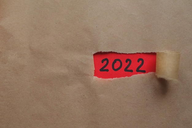 Carta strappata e capodanno 2022 su sfondo rosso